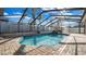 A sparkling pool is enclosed by a screen and pavers, surrounded by lush landscaping at 15701 Springmoss Ln, Tampa, FL 33624