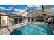 Refreshing in-ground pool under a screened enclosure, perfect for outdoor relaxation at 15701 Springmoss Ln, Tampa, FL 33624