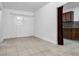 Bright room with tile flooring, white curtains over window, and kitchenette partially divided by burgundy curtain at 15701 Springmoss Ln, Tampa, FL 33624