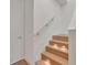 Modern staircase with wood steps, under-step lighting, a brushed metal handrail, and white walls at 1 Aqua Reserve Blvd, New Port Richey, FL 34652