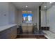 Bright bathroom features tiled walls, a soaking tub, and glass-enclosed shower, plus an outside view at 10 Papaya St # 1404, Clearwater Beach, FL 33767