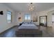 Bright bedroom features gray wood floors, a modern chandelier, and ocean views from multiple windows at 10 Papaya St # 1404, Clearwater Beach, FL 33767