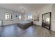 Bright bedroom features gray wood floors, a modern chandelier, and ocean views from multiple windows at 10 Papaya St # 1404, Clearwater Beach, FL 33767