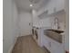 Laundry room equipped with modern washer, dryer, sink and white cabinetry at 10 Papaya St # 1404, Clearwater Beach, FL 33767