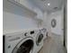 Well-equipped laundry room with a modern washer, dryer, sink, and ample storage at 10 Papaya St # 1404, Clearwater Beach, FL 33767