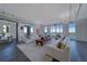 Open concept living room with white sofas, wood floors, and floor-to-ceiling windows with water views at 10 Papaya St # 1404, Clearwater Beach, FL 33767