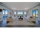 Spacious living room with white sofas, wood floors, and floor to ceiling windows with water views at 10 Papaya St # 1404, Clearwater Beach, FL 33767
