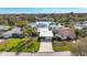 Stunning aerial view of a home with a lush green lawn, palm trees and a lake at 10828 99Th Pl, Seminole, FL 33772