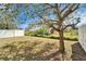 A well-maintained backyard featuring a spacious lawn, tree, and a white fence, perfect for outdoor activities at 12239 Fawn Brindle St, Riverview, FL 33578