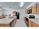 Kitchen features black appliances, wood cabinets and tile flooring at 12239 Fawn Brindle St, Riverview, FL 33578