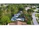 Aerial view of a property with a screened pool, surrounded by lush greenery and residential streets at 16311 Colwood Dr, Odessa, FL 33556