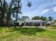 Expansive backyard featuring a screened-in pool, well-maintained lawn, and mature trees offering shade and privacy at 16311 Colwood Dr, Odessa, FL 33556