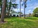 Expansive backyard featuring a screened pool enclosure, bordered by mature trees and a well-maintained lawn at 16311 Colwood Dr, Odessa, FL 33556