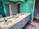 Bright bathroom featuring double sinks, white countertops, and a large mirror at 16311 Colwood Dr, Odessa, FL 33556