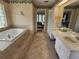 Bright bathroom features a jacuzzi tub, double sinks, and access to the main bedroom at 16311 Colwood Dr, Odessa, FL 33556