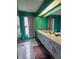 Bright bathroom featuring a double sink vanity, a large mirror, and colorful decor at 16311 Colwood Dr, Odessa, FL 33556