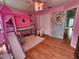 Cute bedroom with hardwood floors, built in lofted bed with slide, and pink color scheme at 16311 Colwood Dr, Odessa, FL 33556