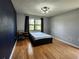 Bedroom with hardwood floors, a large window, and blue accent wall at 16311 Colwood Dr, Odessa, FL 33556