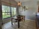 Dining area featuring a wood table, seating for four, a decorative pendant light, tile floors, and natural light at 16311 Colwood Dr, Odessa, FL 33556