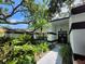 Charming home exterior featuring lush tropical landscaping, a walkway, and a striking black and white color scheme at 16311 Colwood Dr, Odessa, FL 33556