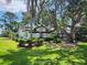 Well-maintained single Gathering home with lush landscaping, mature trees, and a beautiful green lawn at 16311 Colwood Dr, Odessa, FL 33556