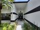 Inviting front entrance featuring a covered entryway, double doors, and lush landscaping at 16311 Colwood Dr, Odessa, FL 33556