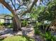 Charming single Gathering home featuring a landscaped front yard, mature tree and a bench at 16311 Colwood Dr, Odessa, FL 33556