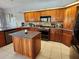 Well-appointed kitchen with wood cabinets, stone countertops, and stainless steel appliances at 16311 Colwood Dr, Odessa, FL 33556