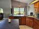 Warm kitchen featuring wood cabinetry, island with seating, and a view to the dining area at 16311 Colwood Dr, Odessa, FL 33556