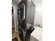 Modern stackable washer and dryer next to a utility sink and folding table in the laundry room at 16311 Colwood Dr, Odessa, FL 33556
