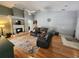 Spacious living room with hardwood floors, a fireplace, leather seating, and a ceiling fan at 16311 Colwood Dr, Odessa, FL 33556