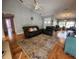 Spacious living room with hardwood floors, comfortable seating, and a view into another living space at 16311 Colwood Dr, Odessa, FL 33556