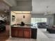 Inviting living room featuring a wet bar with wood cabinets and direct access to the outdoor pool area at 16311 Colwood Dr, Odessa, FL 33556