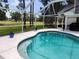 Beautiful pool with bright blue water with a view of the lush green lawn and mature trees at 16311 Colwood Dr, Odessa, FL 33556
