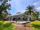 A screened-in pool area with a palm tree, providing a private and relaxing outdoor oasis at 16311 Colwood Dr, Odessa, FL 33556