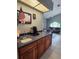 Wet bar featuring wood cabinets, granite countertops, and a view into the adjacent living room at 16311 Colwood Dr, Odessa, FL 33556