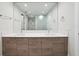 A modern bathroom has double sinks with wood cabinets and a walk-in glass shower, complemented by ample lighting and closet space at 301 1St S St # 1605, St Petersburg, FL 33701