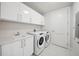 Bright laundry room with front load washer/dryer, white cabinets and sink with countertop at 301 1St S St # 1605, St Petersburg, FL 33701
