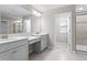 Elegant bathroom with double sink vanity, tiled floors, and walk-in shower at 32346 Sapna Chime Dr, Wesley Chapel, FL 33545