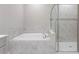 Bathroom featuring a tub, walk-in shower, and tiled walls at 32346 Sapna Chime Dr, Wesley Chapel, FL 33545