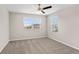 Well-lit bedroom featuring neutral carpet, ceiling fan and two windows at 32346 Sapna Chime Dr, Wesley Chapel, FL 33545