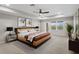 Warm bedroom offers a tray ceiling, fan, bedside tables, and an exterior door and window at 32346 Sapna Chime Dr, Wesley Chapel, FL 33545