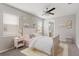 Charming bedroom with cloud décor, a ceiling fan, and a view into the bathroom at 32346 Sapna Chime Dr, Wesley Chapel, FL 33545