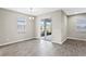 Dining area with gray wood floors, a modern light fixture, and access to the patio at 32346 Sapna Chime Dr, Wesley Chapel, FL 33545