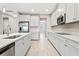 Galley kitchen featuring white cabinetry, stainless steel appliances, light countertops, and light wood-look flooring at 32346 Sapna Chime Dr, Wesley Chapel, FL 33545