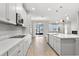 Charming kitchen showcases an island, white cabinets, stainless steel appliances, and access to the outdoor living space at 32346 Sapna Chime Dr, Wesley Chapel, FL 33545