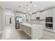 Spacious kitchen with island features stainless steel appliances, white cabinets, light countertops, and modern pendant lighting at 32346 Sapna Chime Dr, Wesley Chapel, FL 33545