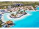 Beautiful lagoon with sandy beach, tiki huts, and lounge chairs at 32346 Sapna Chime Dr, Wesley Chapel, FL 33545