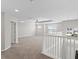 Large loft area with neutral carpet, ceiling fan, ample natural light, and staircase with white railing at 32346 Sapna Chime Dr, Wesley Chapel, FL 33545