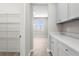 Walk-in pantry with white wire shelving and white cabinets, providing ample storage space with easy organization at 32346 Sapna Chime Dr, Wesley Chapel, FL 33545